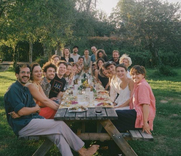 A long outdoor table full of people at golden hour