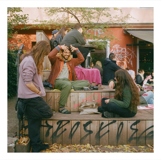 Friends sitting on a wooden terrace in autumn
