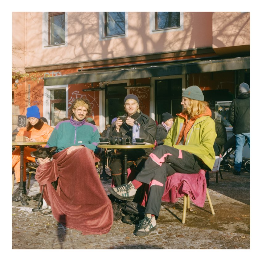 Friends bundled in blankets outside a Berlin cafe in winter